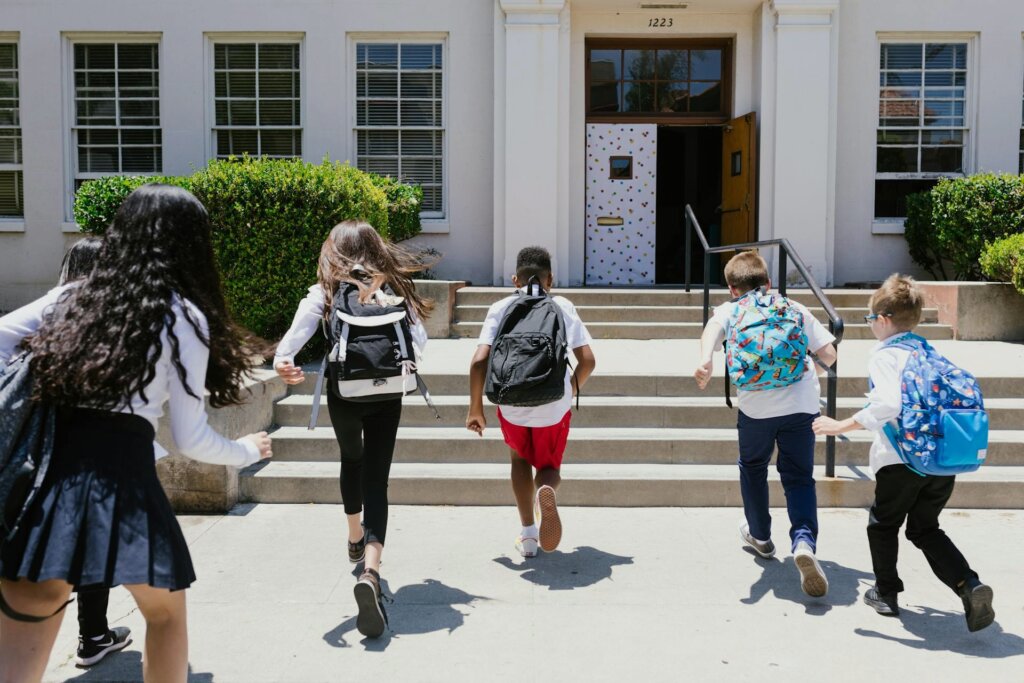 Photo of children running towards a school building door
