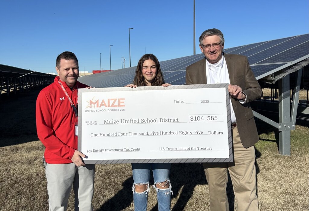 Image of Maize Unified School District 266 (Kansas) staff holding a $104,585 check for a solar panel array.